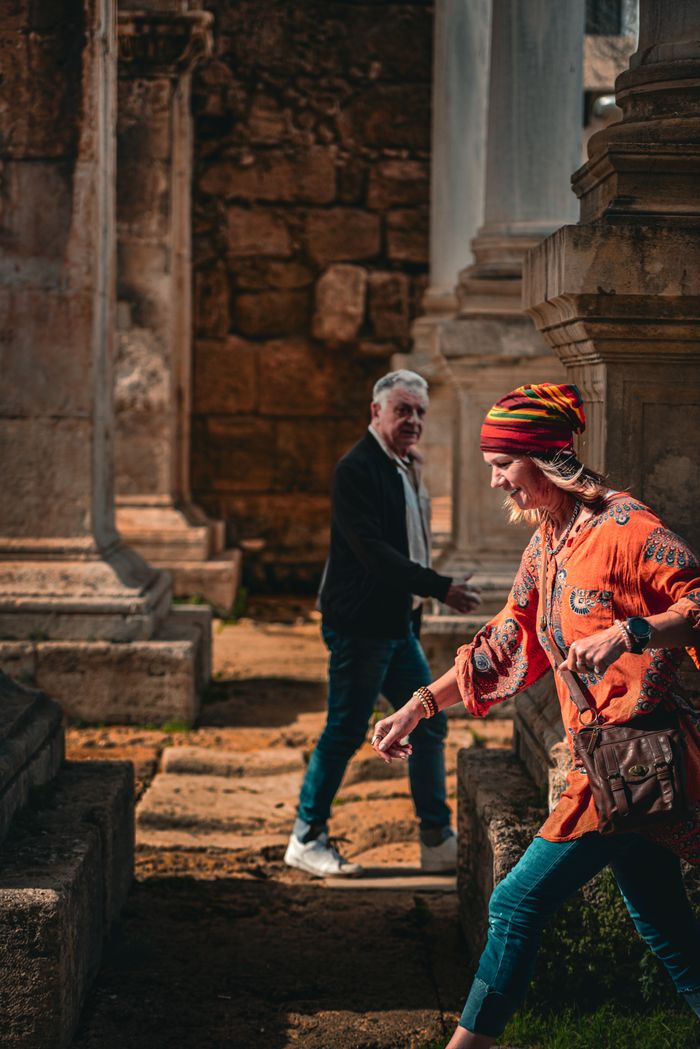 brand-03 Happy couple strolling through ancient stone ruins on a sunny day.