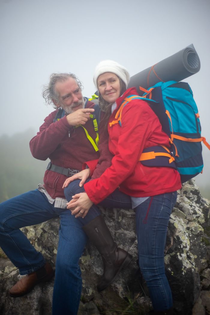 Elderly couple hiking and enjoying nature in misty Portuguese mountains, showcasing love and adventure.