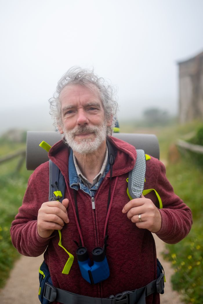 creative-01 Senior man enjoying a misty hike in the countryside of Portugal, embodying adventure and vitality.